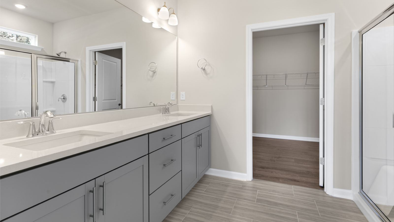 primary bathroom with walk in shower and dual vanity sinks