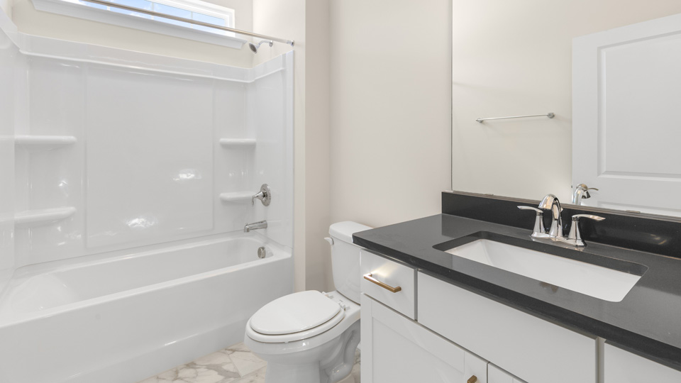 secondary bathroom with shower tub combo and single vanity sink