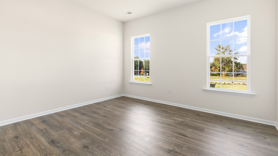 primary bedroom with two windows and revwood, attached bath