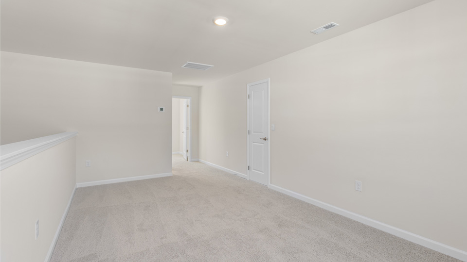 upstairs loft area with large windows and carpeting