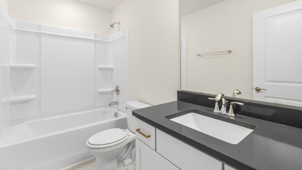 secondary bathroom with shower tub combo and single vanity sink