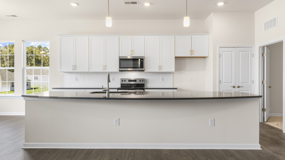 kitchen with quartz counters, kitchen island, pantry, stainless steel appliances