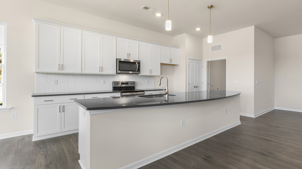 kitchen with quartz counters, kitchen island, pantry, stainless steel appliances