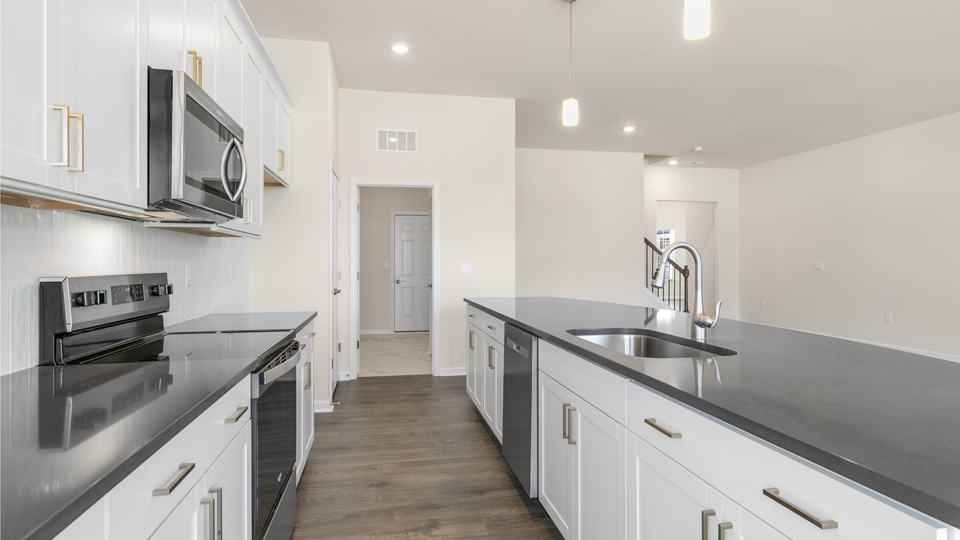 kitchen with quartz counters, kitchen island, pantry, stainless steel appliances