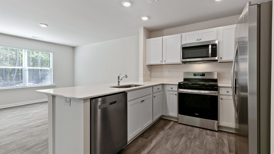 kitchen with quartz counters, kitchen island, pantry, stainless steel appliances