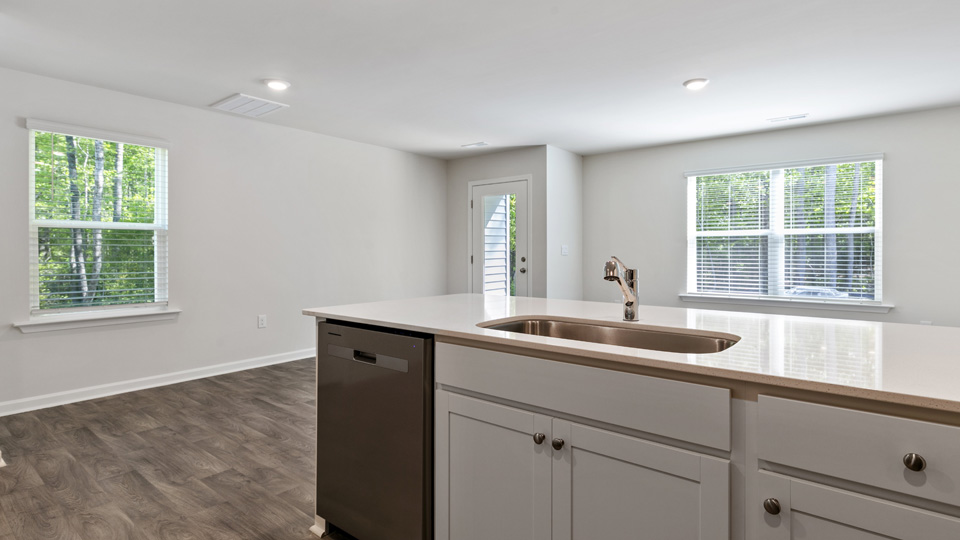 kitchen with quartz counters, kitchen island, pantry, stainless steel appliances