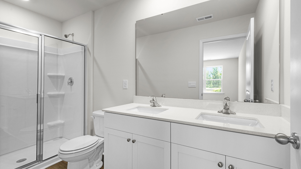 Primary bathroom with double sink and walk-in shower