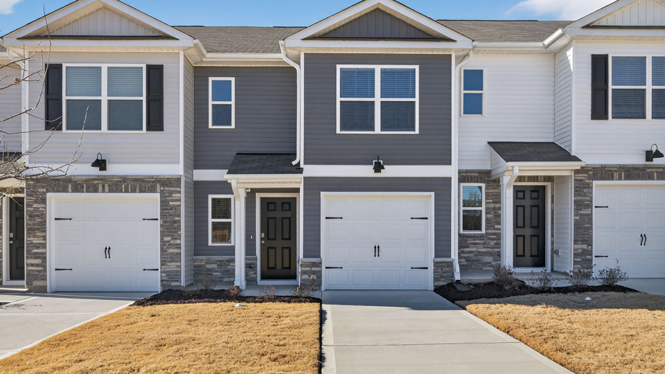 Two story town home with gray siding & garage