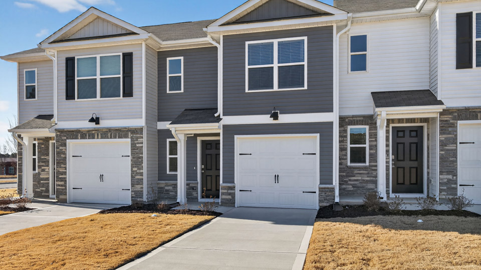 Two story town home with gray siding & garage