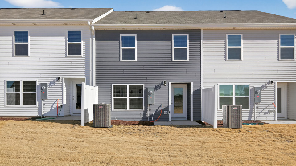 Two story town home with gray siding & backyard area