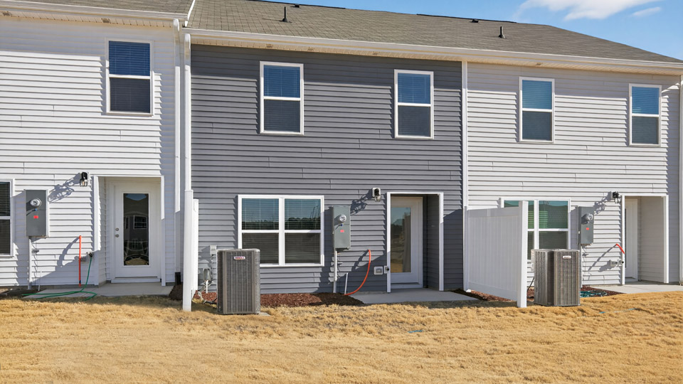 Two story town home with gray siding & backyard area