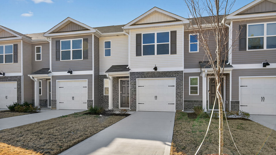 Two story town home with white siding.