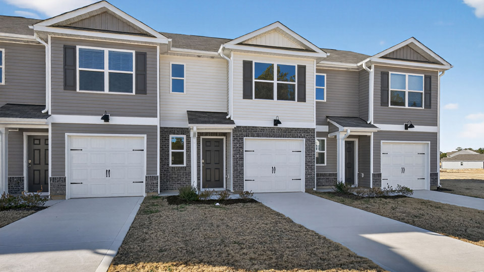 Two story town home with white siding.