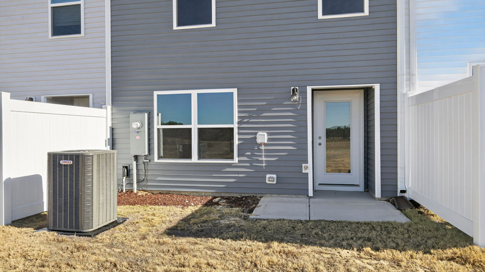 Two story town home with blue siding & patio