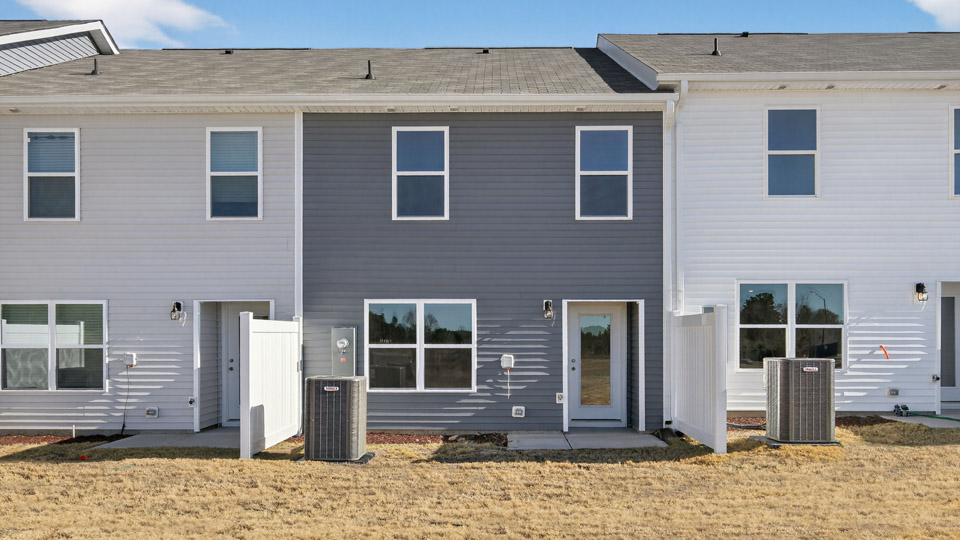Two story town home with blue siding & patio