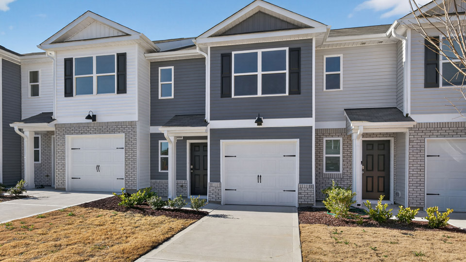 Two story town home with blue siding & garage
