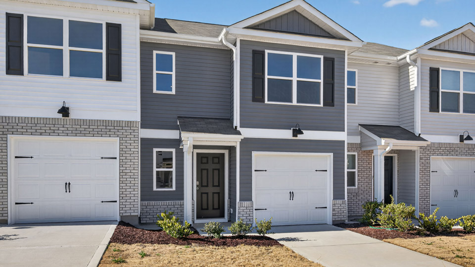 Two story town home with blue siding & garage