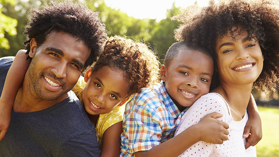 young couple with kids on piggy back