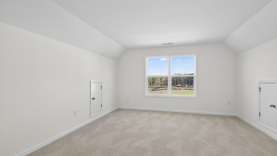bonus room with vaulted ceiling and carpet flooring