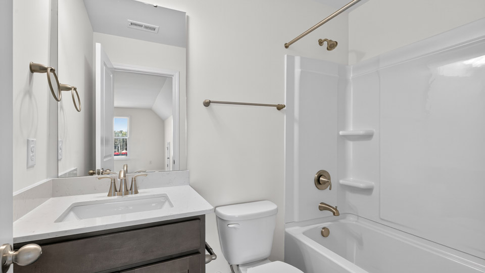 bathroom with brown cabinets and tub shower combo
