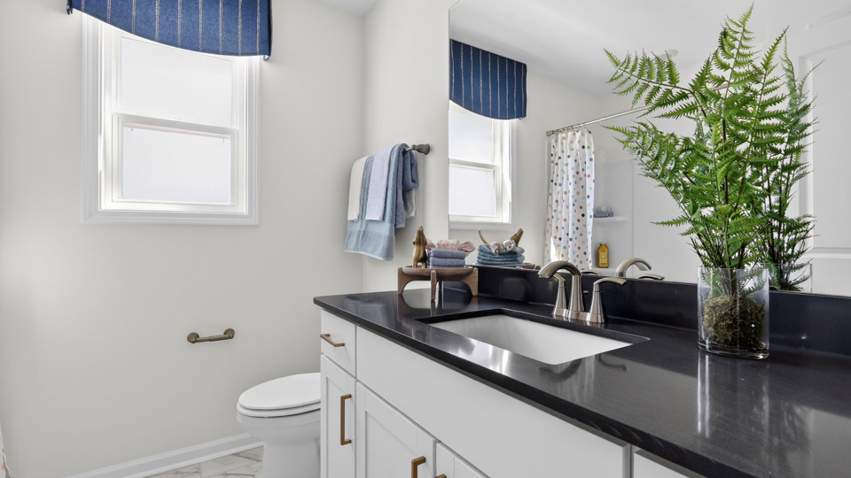 bathroom with quartz countertops and white cabinets