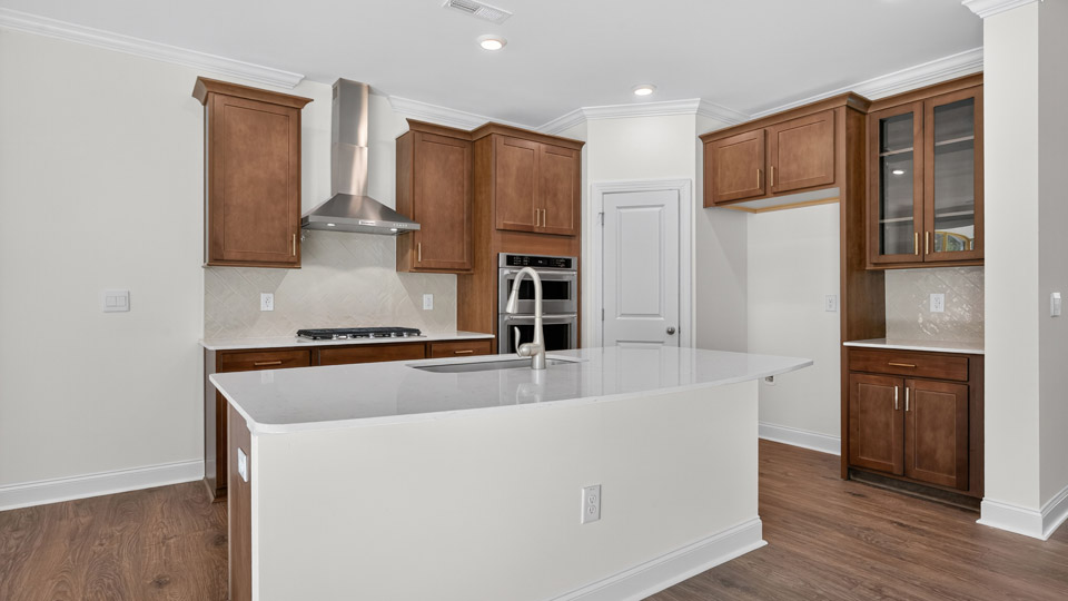 kitchen with brown cabinets stainless steel appliances and quartz countertops