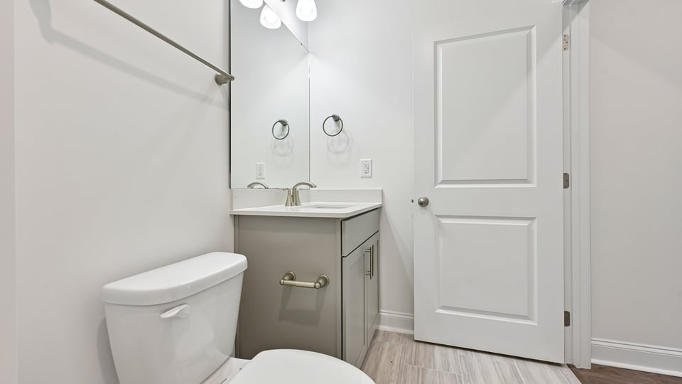 bathroom with gray cabinets tub shower combo and quartz countertops