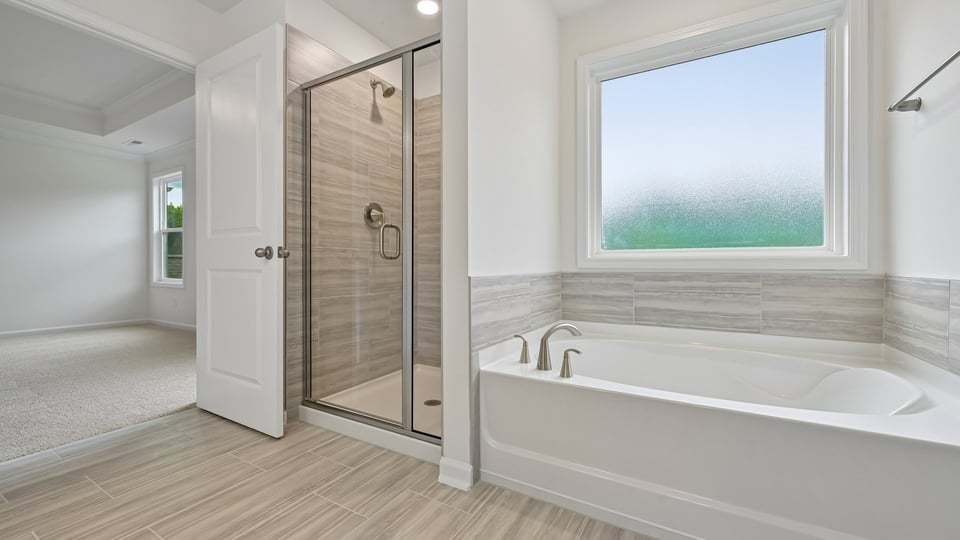 bathroom with separate tub and shower with glass doors