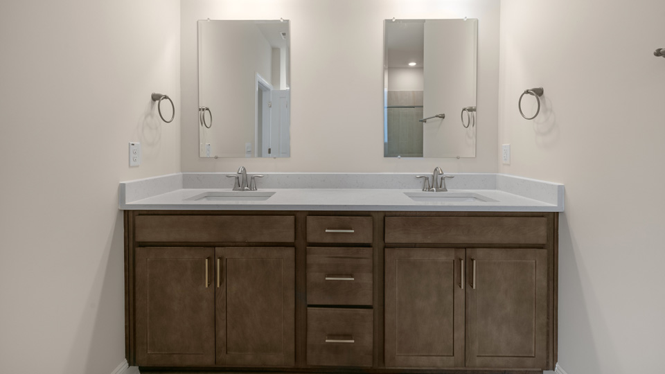 Bathroom with quartz countertops and brown cabinets