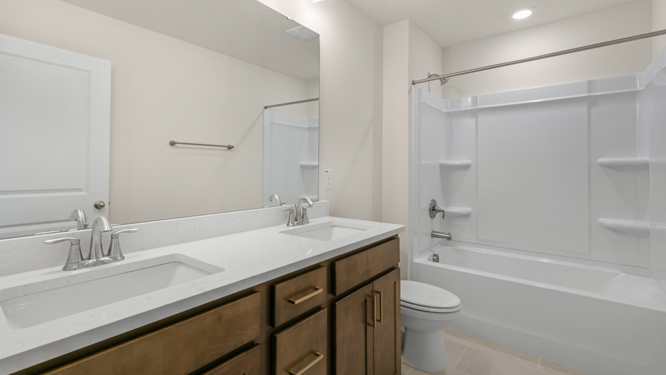 Bathroom with quartz countertops and brown cabinets