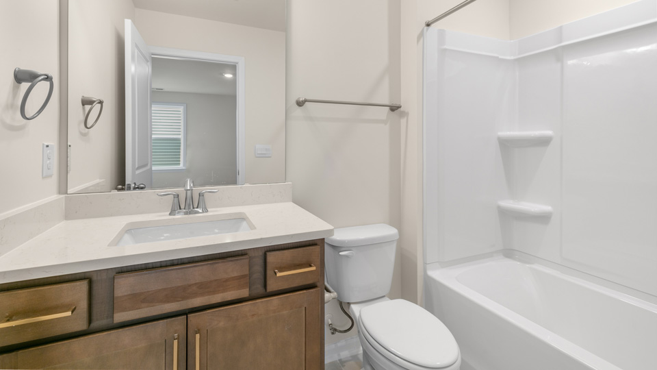 Bathroom with quartz countertops and brown cabinets