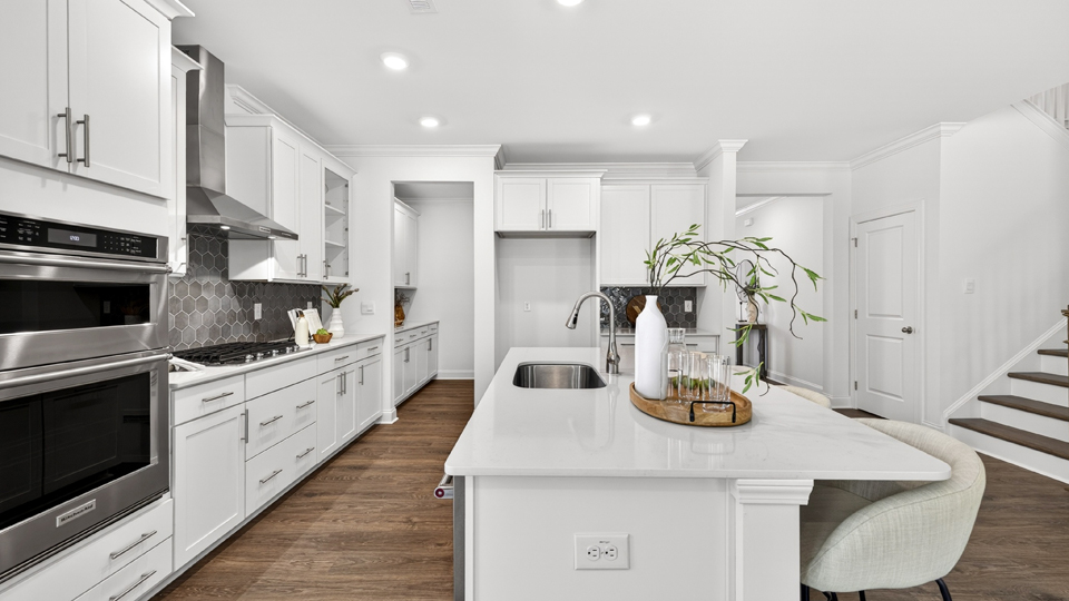 kitchen with quartz counters, kitchen island, pantry, stainless steel appliances