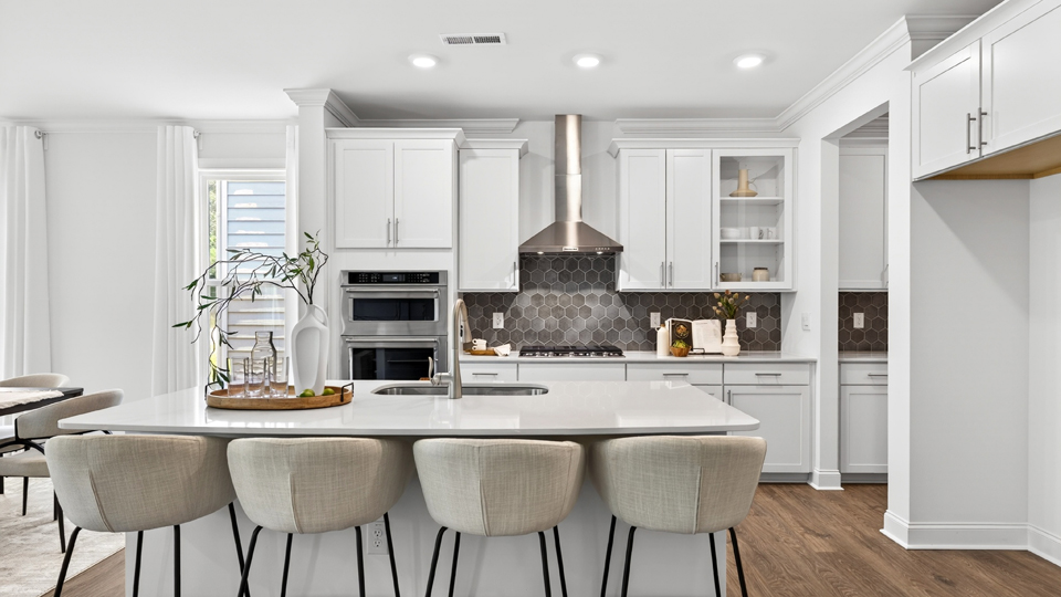 kitchen with quartz counters, kitchen island, pantry, stainless steel appliances