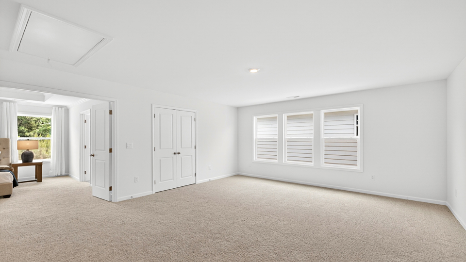 upstairs loft area with large windows and carpeting