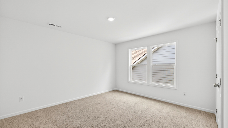 secondary bedroom with window and closet, carpeting