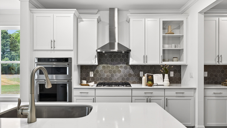 kitchen with quartz counters, kitchen island, pantry, stainless steel appliances