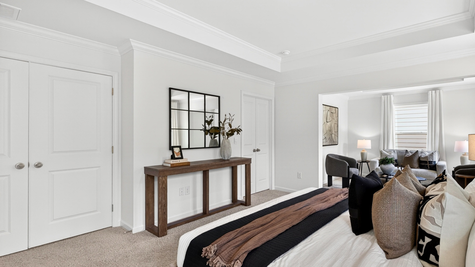 primary bedroom with two windows and carpeting, attached bath