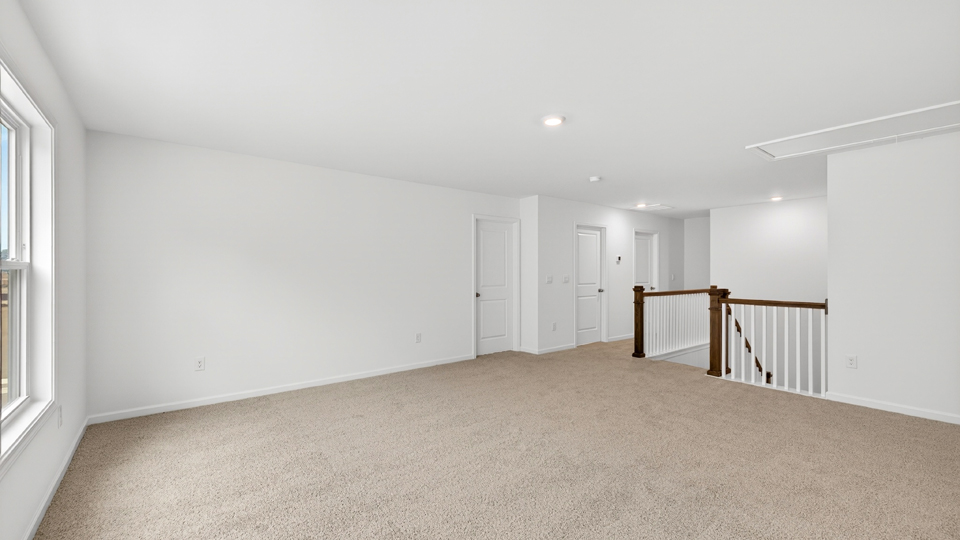upstairs loft area with large windows and carpeting