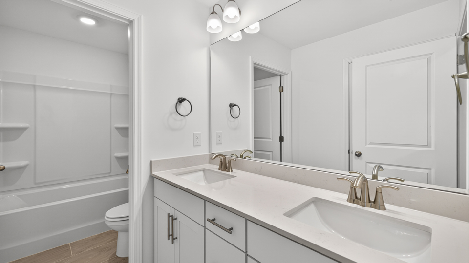 primary bathroom with walk in shower and dual vanity sinks