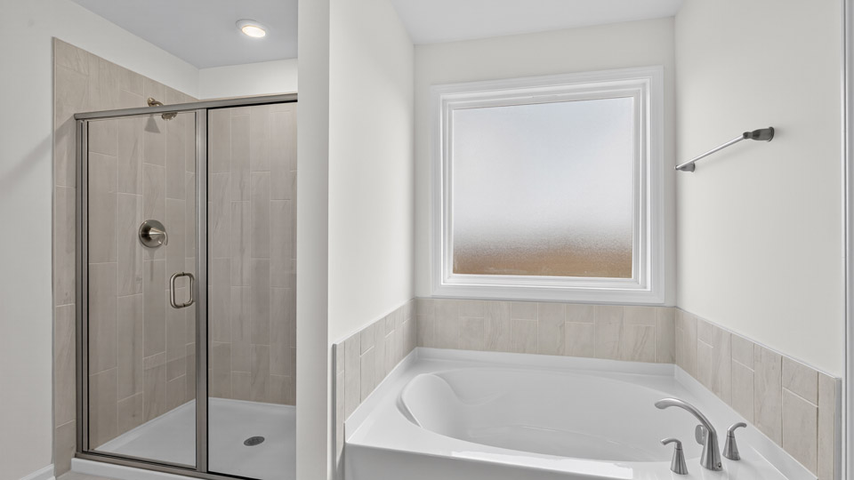 primary bathroom with walk in shower and dual vanity sinks
