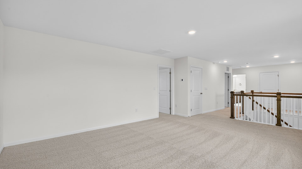 upstairs loft area with large windows and carpeting