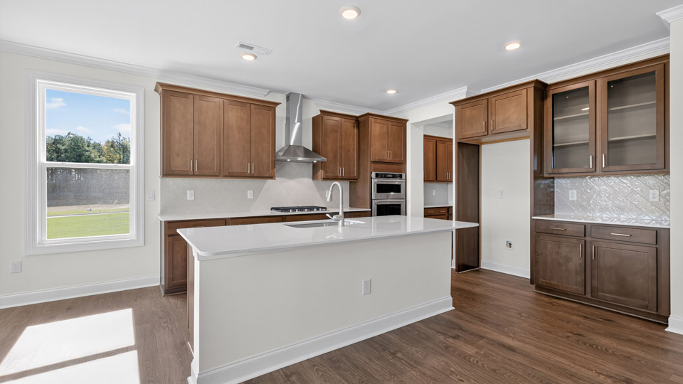 kitchen with quartz counters, kitchen island, pantry, stainless steel appliances