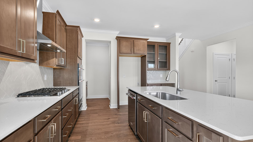 kitchen with quartz counters, kitchen island, pantry, stainless steel appliances