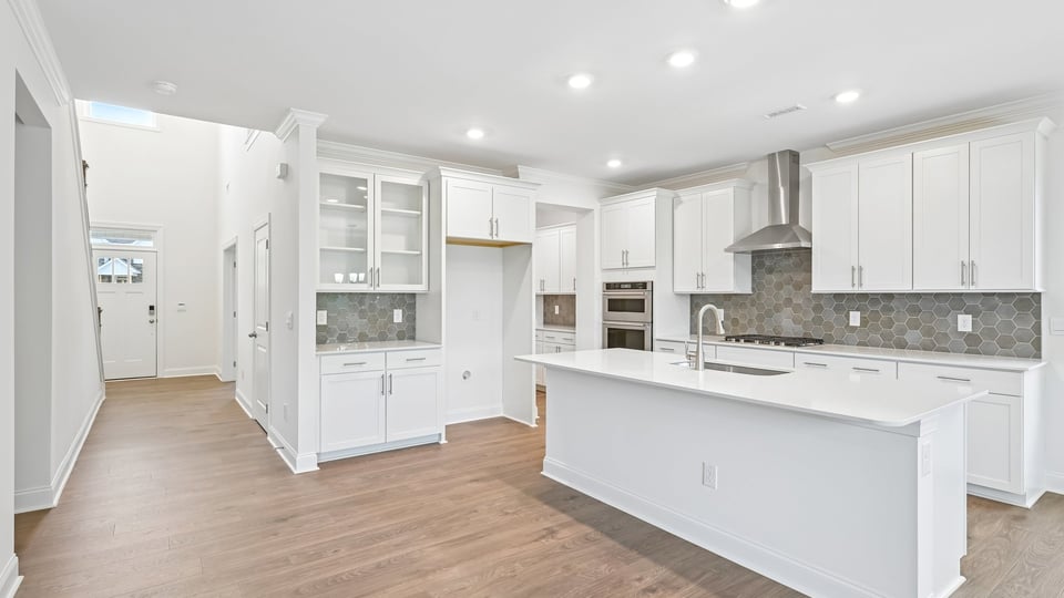kitchen with quartz counters, kitchen island, pantry, stainless steel appliances