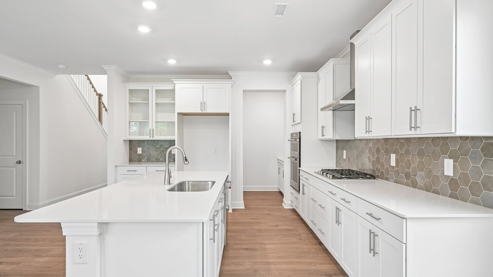 kitchen with quartz counters, kitchen island, pantry, stainless steel appliances
