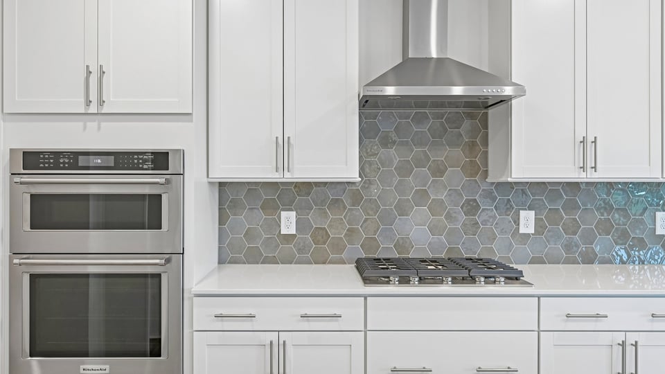 kitchen with quartz counters, kitchen island, pantry, stainless steel appliances