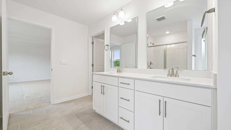 primary bathroom with walk in shower, bathtub, and dual vanity sinks