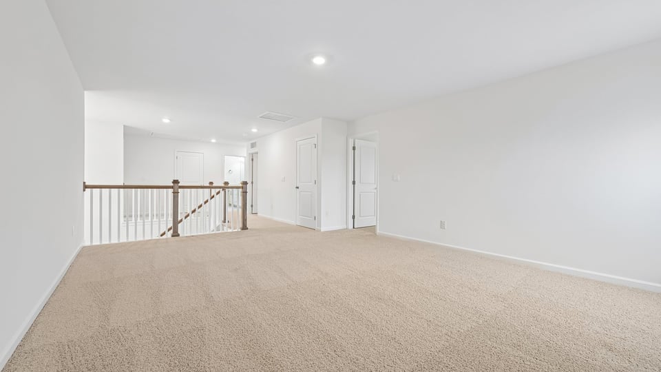 upstairs loft area with large windows and carpeting