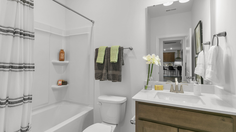 bathroom with tub shower combo and quartz countertops