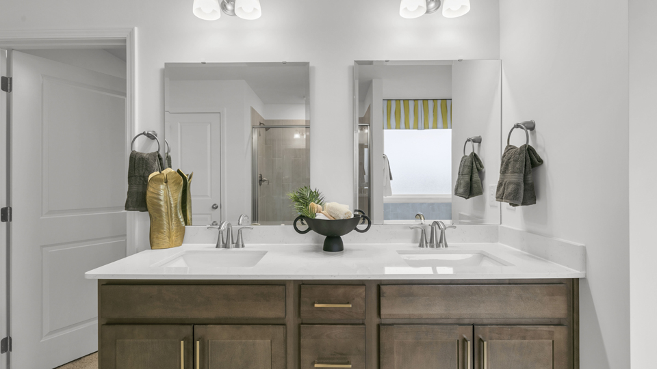 bathroom with quartz countertops brown cabinets and dual vanity